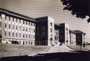 Large imposing multi-story brick building with driveway.
