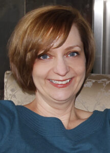 Head and shoulder's photo of woman with blond hair and blue shirt
