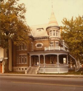 old colour photo of elaborate brick residential home