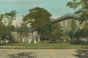 image of old stone wing of large building, female figures in long white dresses, lawn, trees and driveway in front