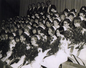 group of young nurses in uniform holding bouquets of flowers