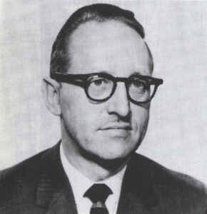 old black and white photograph, 1950s of man with dark hair and glasses