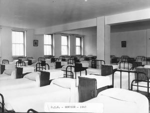 old black and white photo of crowded hospital ward with beds