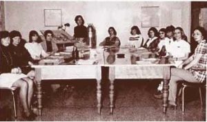 old black and white photo of group of people sitting or standing playing various musical instruments