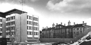 1970s black and white photo showing modern institutional building on the left and old 19th century institutional structure on the right