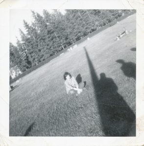 young woman sitting in middle of a playing field