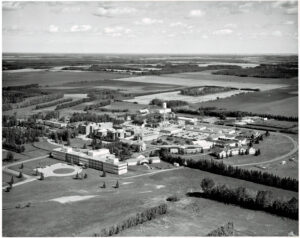 large institution from the air set in prairie fields and some treed areas