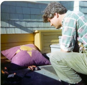 man on roof or balcony looking at pillow