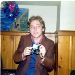 blond haired young man holding camera