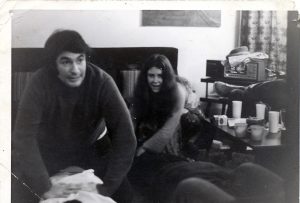 dark haired man and women seated in living room.